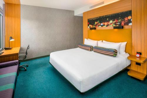 a bedroom with a large white bed in a room at Aloft Bogotá Airport in Bogotá