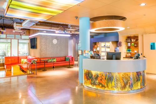 a lobby with couches and tables in a building at Aloft Bogotá Airport in Bogotá
