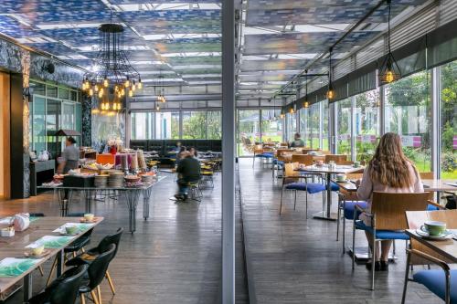 a restaurant with tables and people sitting at tables at Aloft Bogotá Airport in Bogotá