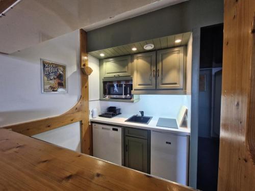 une petite cuisine avec un évier et un micro-ondes dans l'établissement Résidence Nova - Appartement 2 pièces 6 personnes proche des pistes, des commerces, de la garderie et de l'ESF au centre de la station d’Arc 1800 MAE-2038, à Arc 1800