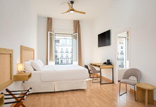 a hotel room with a white bed and a desk at LUTHIA Puerta del Sol in Madrid