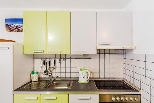 a kitchen with green cabinets and a sink at Apartma Vučič in Bovec
