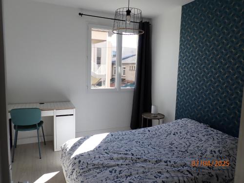a bedroom with a bed and a desk and a window at Escale montferrandaise in Clermont-Ferrand