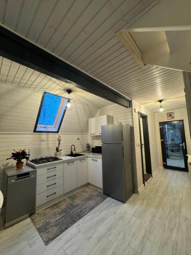 a kitchen with white cabinets and a refrigerator at LKS A-frame in Corbi