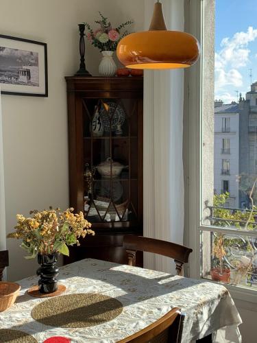 une salle à manger avec une table et une fenêtre dans l'établissement Cozy Frenchy apartment nearby La Seine, à Paris