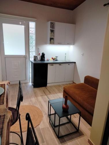 a kitchen and a living room with a couch and a table at Olive apartment in Paianía