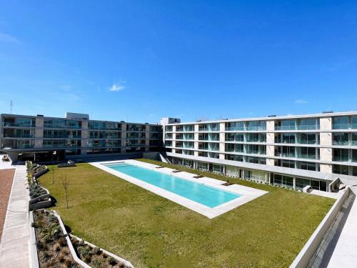 a large apartment building with a large swimming pool at Complejo Prana, pileta, parilla, cine y gimnasio in San Isidro