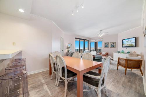 een eetkamer en woonkamer met een tafel en stoelen bij Four Seasons 904W in Orange Beach