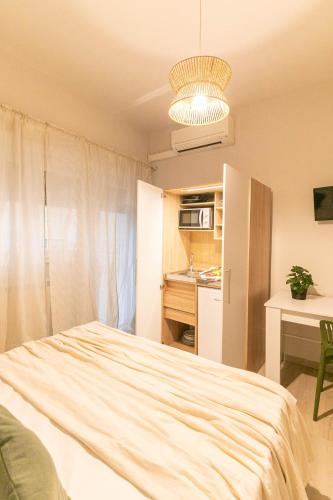 a bedroom with a bed and a table and a kitchen at Dafne Room Suites con terrazza in Rome