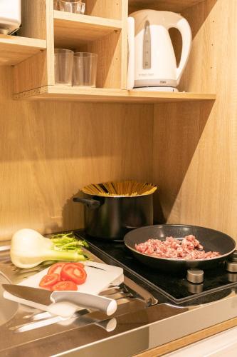 a kitchen stove with a pan of food on it at Dafne Room Suites con terrazza in Rome