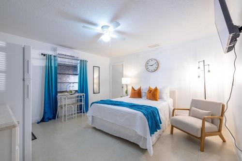 a bedroom with a bed and a chair and a clock at 2 PPL 5 mins to Golf Courses Patio Pets BBQ in Wellington