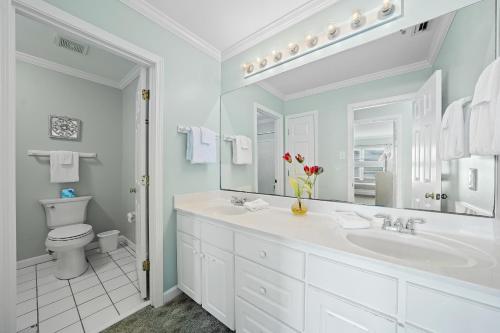 a bathroom with a sink and a toilet and a mirror at Sea-Side in Dauphin Island
