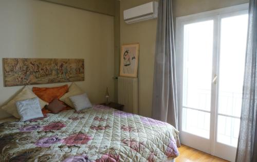 a bedroom with a bed and a large window at The Belgian Connection in Koukaki in Athens