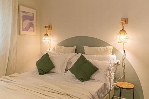 a bed with white sheets and green pillows at Dafne Room Suites con terrazza in Rome