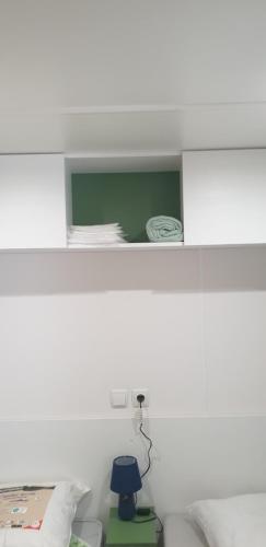 a white room with a bed with a blue lamp at MOBIL HOME n 2 TOUT CONFORT ST CYPRIEN 66 in Saint-Cyprien