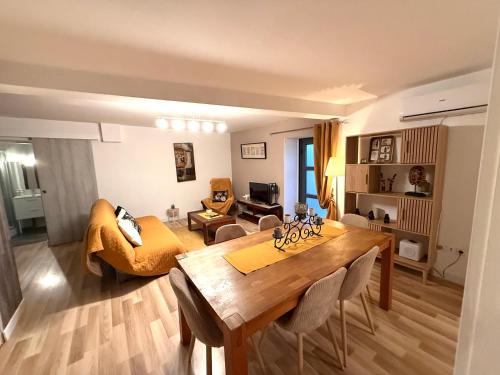 a living room with a dining room table and a couch at Douce Campagne in Le Pouzin