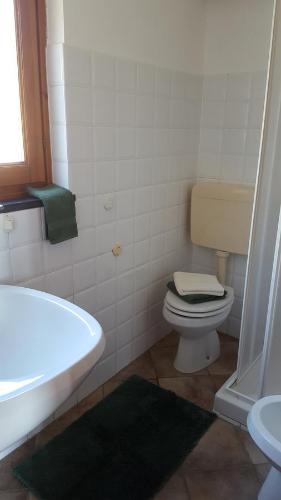 a bathroom with a toilet and a tub and a sink at Agriturismo OlivArancio in Leivi