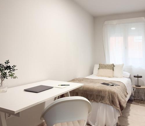 a bedroom with a desk and a bed with a desk and chairs at ChillaHomes 101 in Candeleda