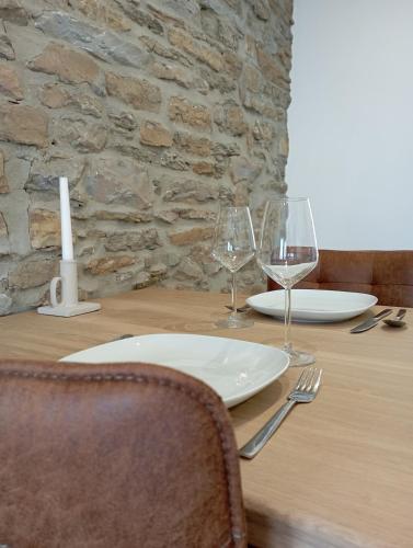 una mesa de madera con dos copas de vino y una vela en studio L'opale, en Assesse
