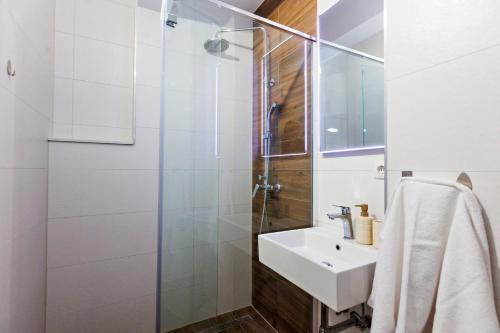 ein Badezimmer mit Waschbecken und Dusche in der Unterkunft Villa Trapezium - private heated pool & table soccer in Kaštela