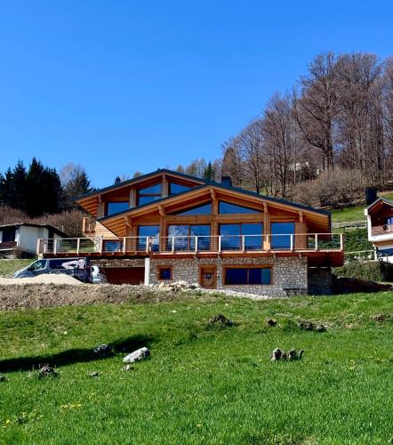 a large house on top of a grassy hill at La Fenestra Cadore - Dolomiti in Pieve di Cadore