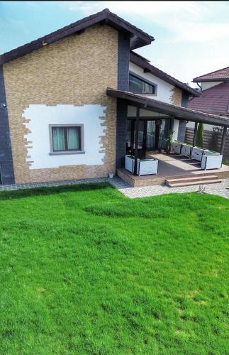 a house with a green lawn in front of it at Villa Montana in Braşov