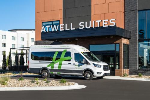 a white van parked in front of a building at Atwell Suites Kansas City Airport by IHG in Kansas City