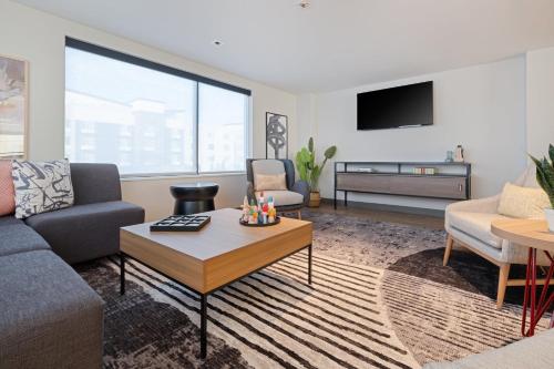 a living room with a couch and a table at Atwell Suites Kansas City Airport by IHG in Kansas City