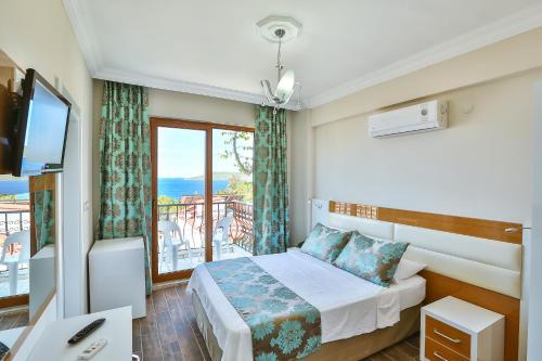 a hotel room with a bed and a window at Hotel Kayahan in Kas