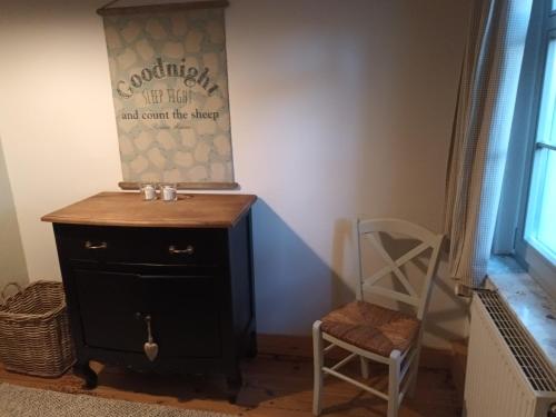 a room with a black dresser and a chair at landhaus rosmarin in Oschersleben