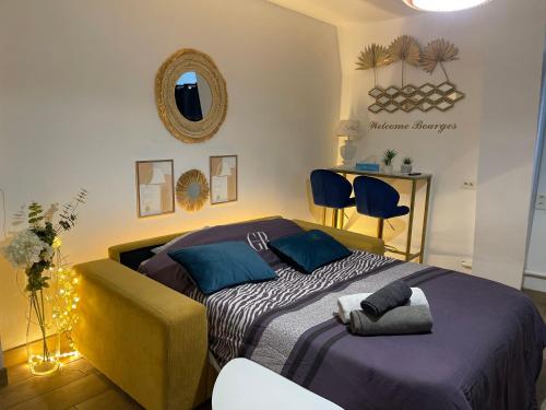 une chambre avec un lit avec des oreillers bleus et un miroir dans l'établissement Hyper centre ville 2 personnes Studio 1 pièce, à Bourges