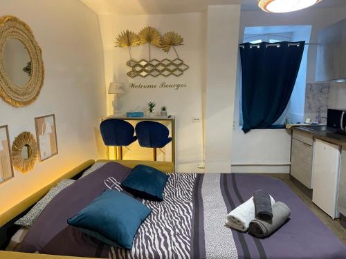 une chambre avec un lit avec des oreillers bleus dessus dans l'établissement Hyper centre ville 2 personnes Studio 1 pièce, à Bourges