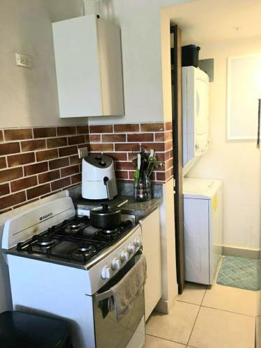 a kitchen with a stove and a brick wall at Great 1 bedroom apartment by the beach CHame, Playa Caracol in El Quindio