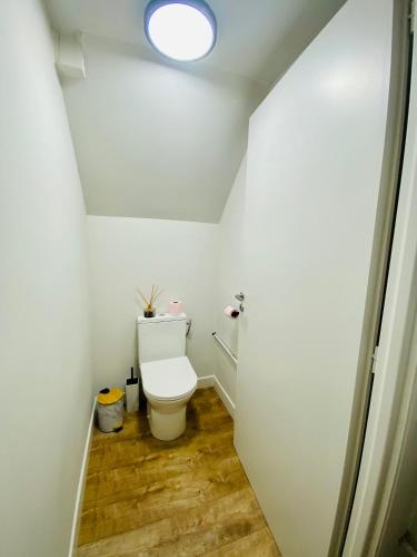 - une salle de bains avec toilettes dans une chambre blanche dans l'établissement La Petite Maison du Moulin, à Salviac