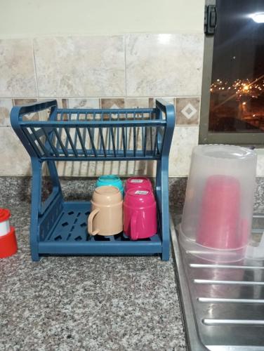a blue dish rack sitting on a counter with cups at Apartamento familiar in Cuenca