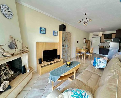 a living room with a couch and a fireplace at Top Floor Apartments in Pefkohori