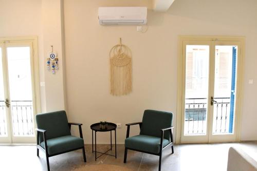 a living room with two chairs and a table at Aegina-town-old-center in Aegina Town