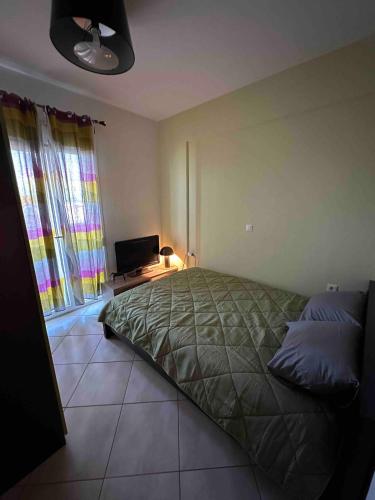 a bedroom with a bed and a television in it at Top Floor Apartments in Pefkohori