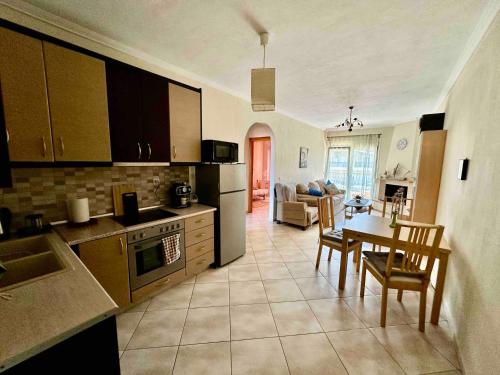 a kitchen and living room with a table and a dining room at Top Floor Apartments in Pefkohori