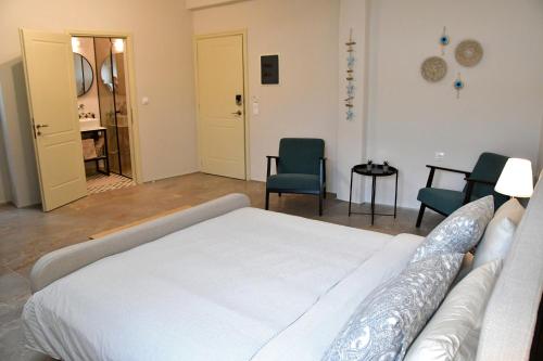 a bedroom with a bed and two chairs and a table at Aegina-town-old-center in Aegina Town