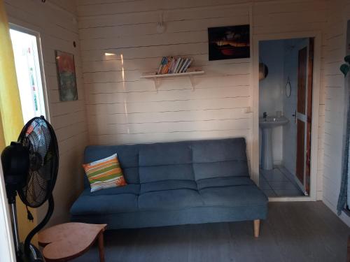 a living room with a blue couch in a room at Bungalow au soleil in Saint-François