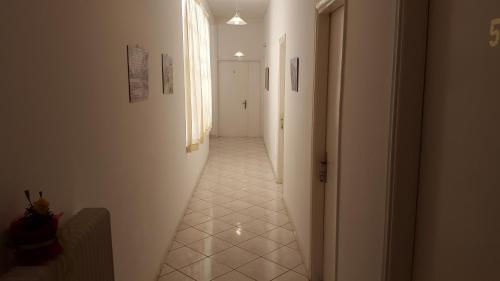 a hallway with a long corridor with white walls at Epic Rooms in Delfoi