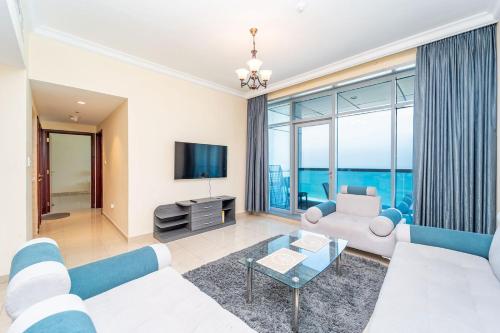 Una sala de estar con un sofá y un televisor. en Ocean View Luxury Suites, en Ajman