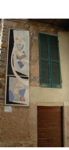 a building with a poster and a window and a door at Casa vacanze al Castello. in Mugnano