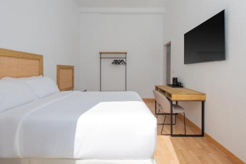 a bedroom with a bed and a desk and a tv at LUTHIA Puerta del Sol in Madrid