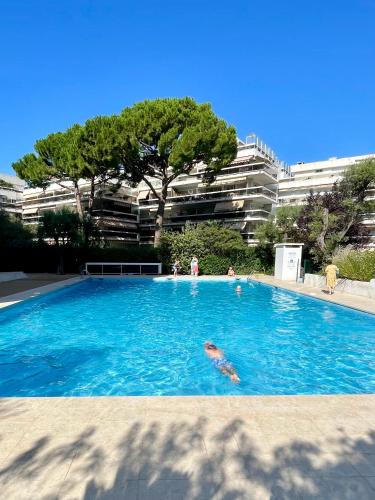 un groupe de personnes nageant dans une piscine dans l'établissement Family apartment - Fully equipped, Close to sandy beaches & restaurants, Pool, Balcony, Garage, à Antibes
