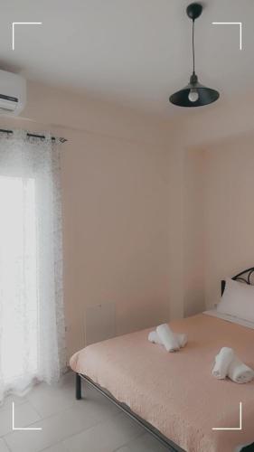 a white bedroom with a bed and a window at ANNA DANIIL New Apartment in Arisvi - Kalloni in Kalloni