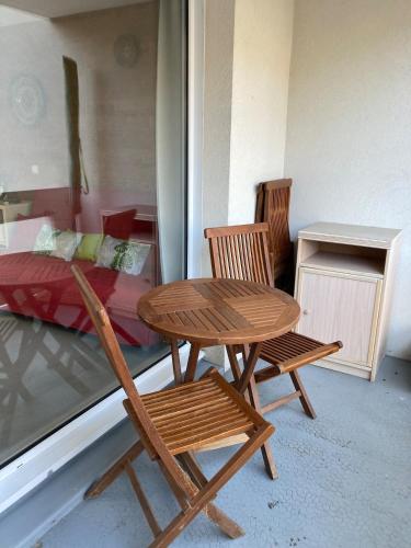 - une table et deux chaises dans une chambre avec un lit dans l'établissement Appartement face aux thermes Allevard, à Allevard