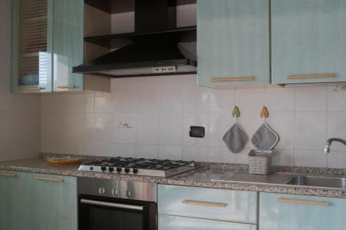 a kitchen with white cabinets and a stove top oven at DeGasperi Home in Manfredonia