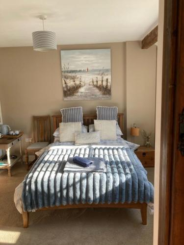Milborne Saint AndrewにあるGuest Suite at 31 Little Englandのベッドと壁に絵が飾られた寝室